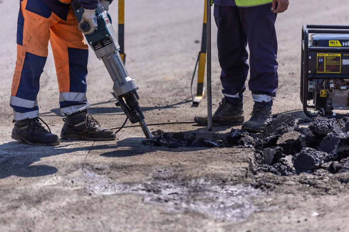 Demolition crew breaking up a concrete floor with jackhammers on a commercial job