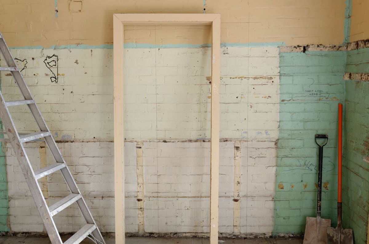 Interior strip-out tools resting against demolished wall framing