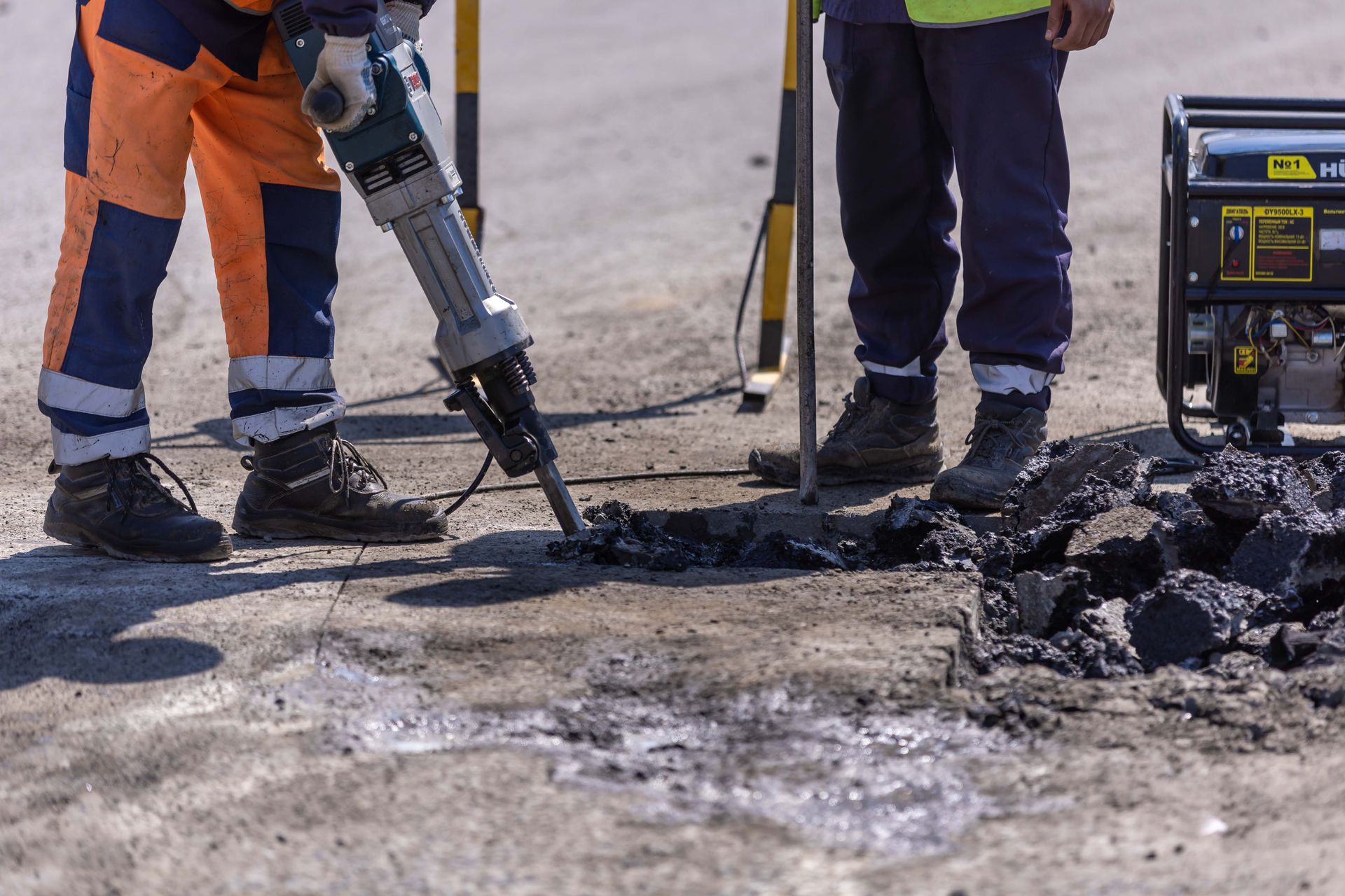 Worker using a heavy-duty jackhammer for concrete floor demolition and removal.